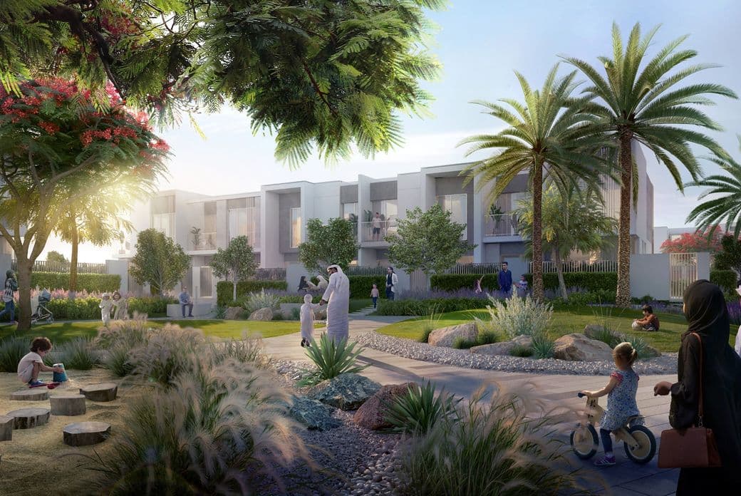 A vibrant community park with people walking, children playing, and modern white buildings surrounded by lush greenery and palm trees.