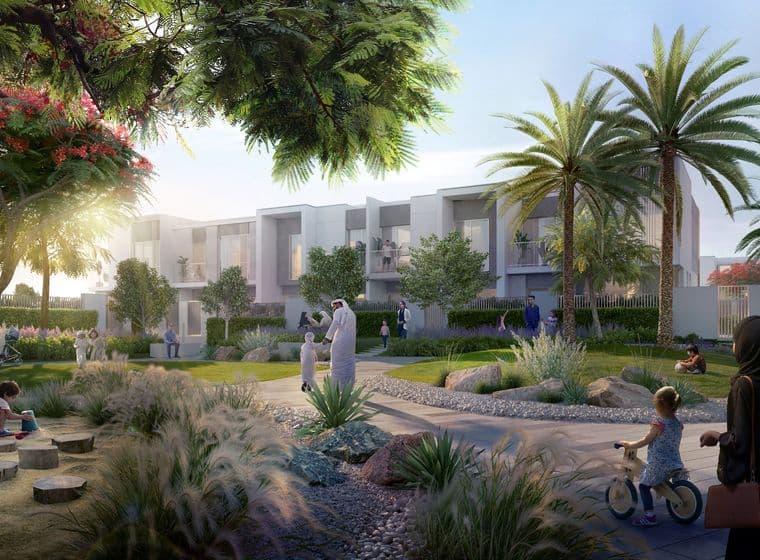 A vibrant community park with people walking, children playing, and modern white buildings surrounded by lush greenery and palm trees.
