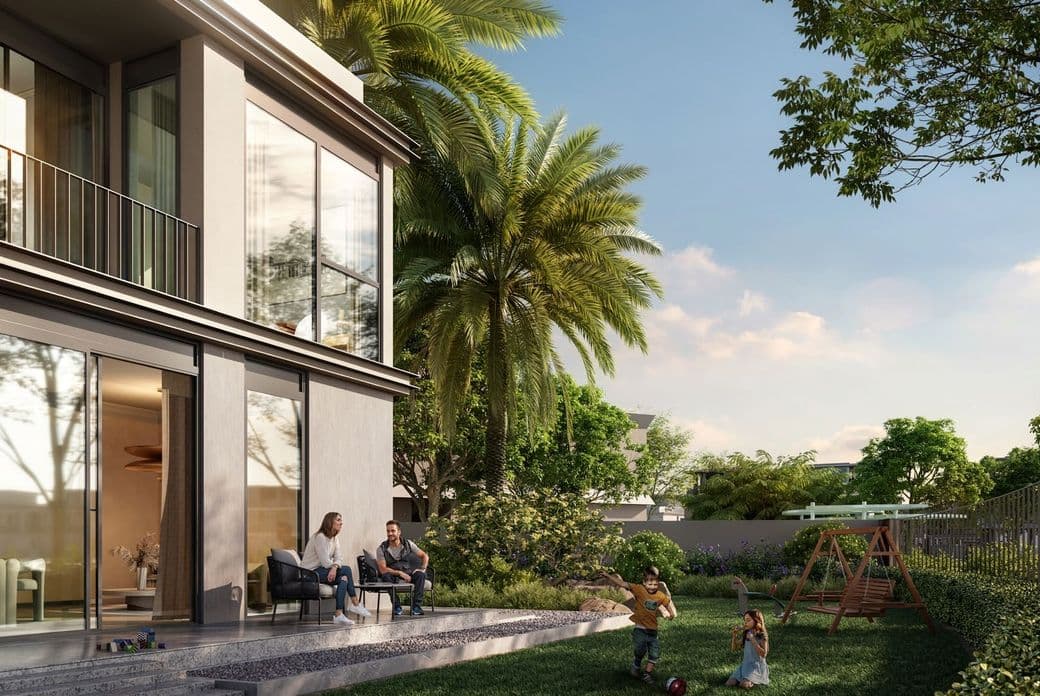 A modern house with a lush garden; a couple sits on the patio while children play near a swing set amid trees under a blue sky.
