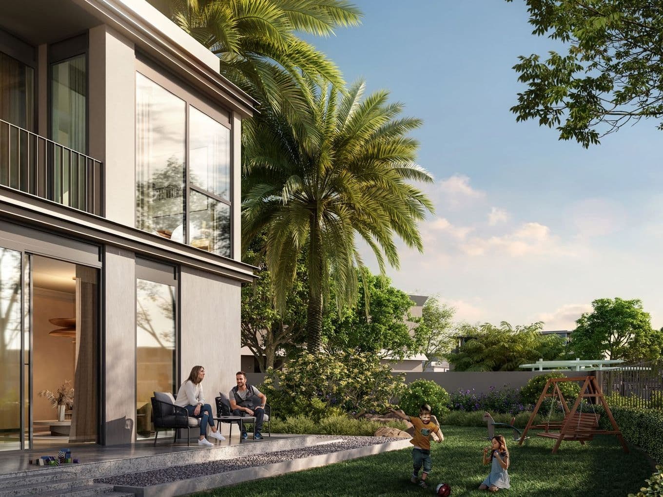 A modern house with a lush garden; a couple sits on the patio while children play near a swing set amid trees under a blue sky.