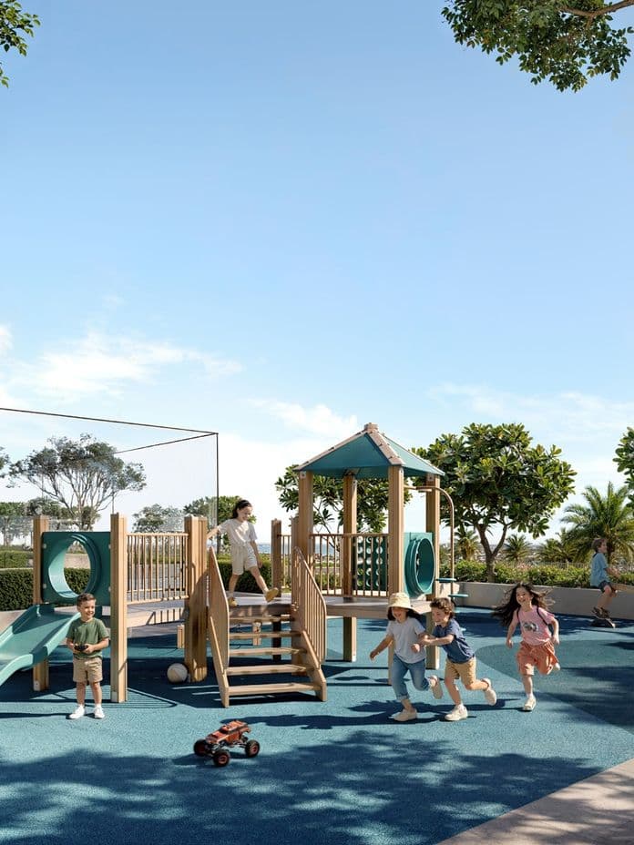 Family-friendly outdoor play area at Sera 2, featuring slides, climbing structures, and kids playing under lush greenery with residential towers in the background.