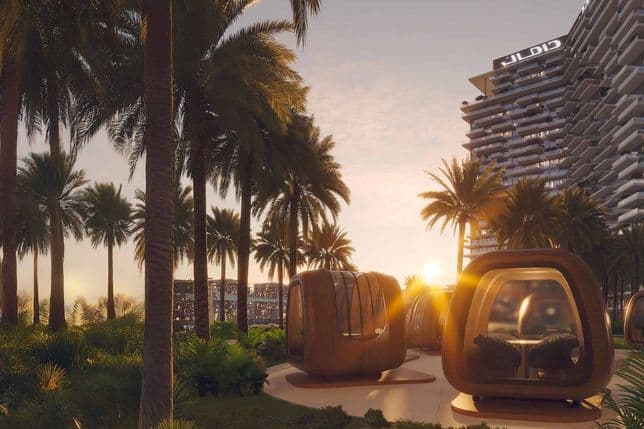 Modern architectural pods and palm trees at sunset, with a futuristic building in the background, creating a serene, tropical cityscape.