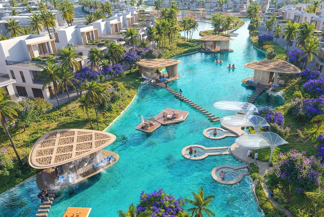 Luxurious villas surrounded by lush greenery and purple flowers, with an azure swimming pool featuring floating platforms and modern shelters.
