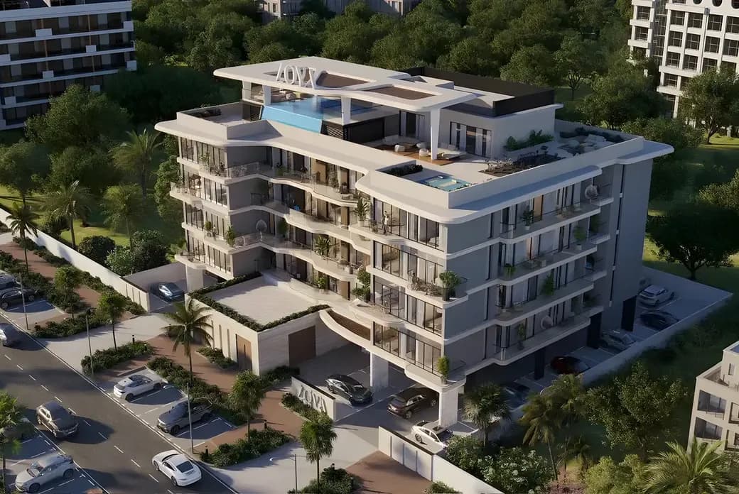 Modern multi-story apartment building with balconies, rooftop pool, and greenery, surrounded by lush trees and parked cars along the street.