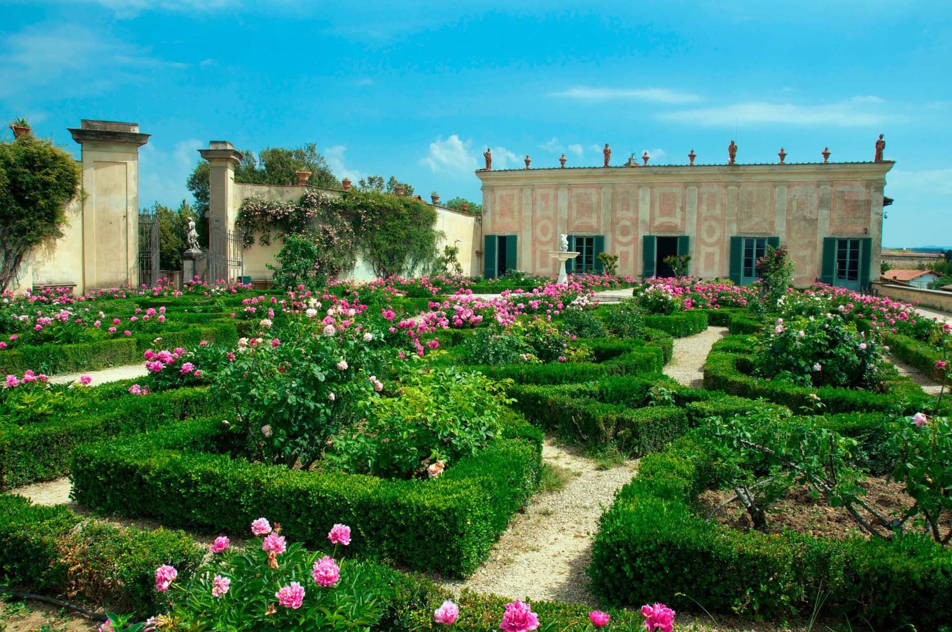 A historic Italian garden with symmetrical paths, impressive sculptures and manicured green spaces in the Boboli Gardens in Florence, Italy.