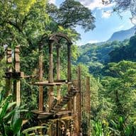 Ein surrealer Garten mit üppigem Dschungel, verwunschenen Skulpturen und mystischen Betonstrukturen in Las Pozas, Mexiko.