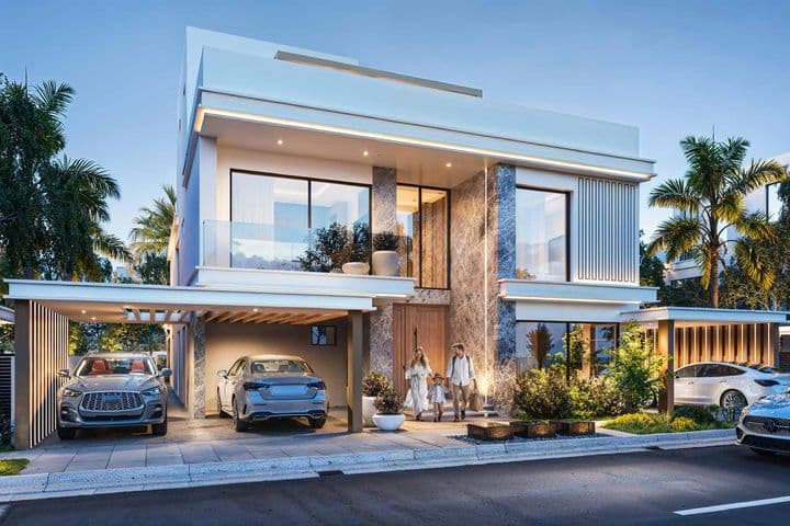 Modern villa at dusk with large windows, a driveway featuring two cars, and a family of three walking towards the entrance. Palms surround the house.
