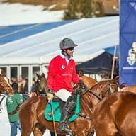 A polo player on a white horse at the snow polo tournament in Kitzbühel.