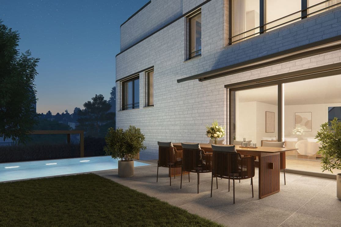 Modernes Haus in der Abenddämmerung mit beleuchtetem Swimmingpool, Essbereich im Freien und großen Glasschiebetüren, die zu einem warm beleuchteten Innenraum führen.