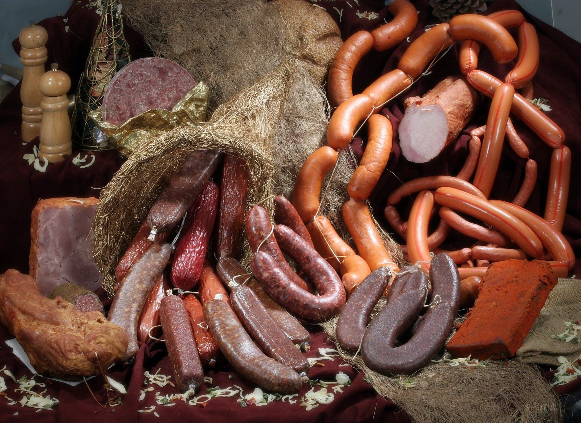 Eine Auswahl an traditionellen Tiroler Wurstwaren, darunter Speck, Salami und geräucherte Würste, kunstvoll arrangiert.