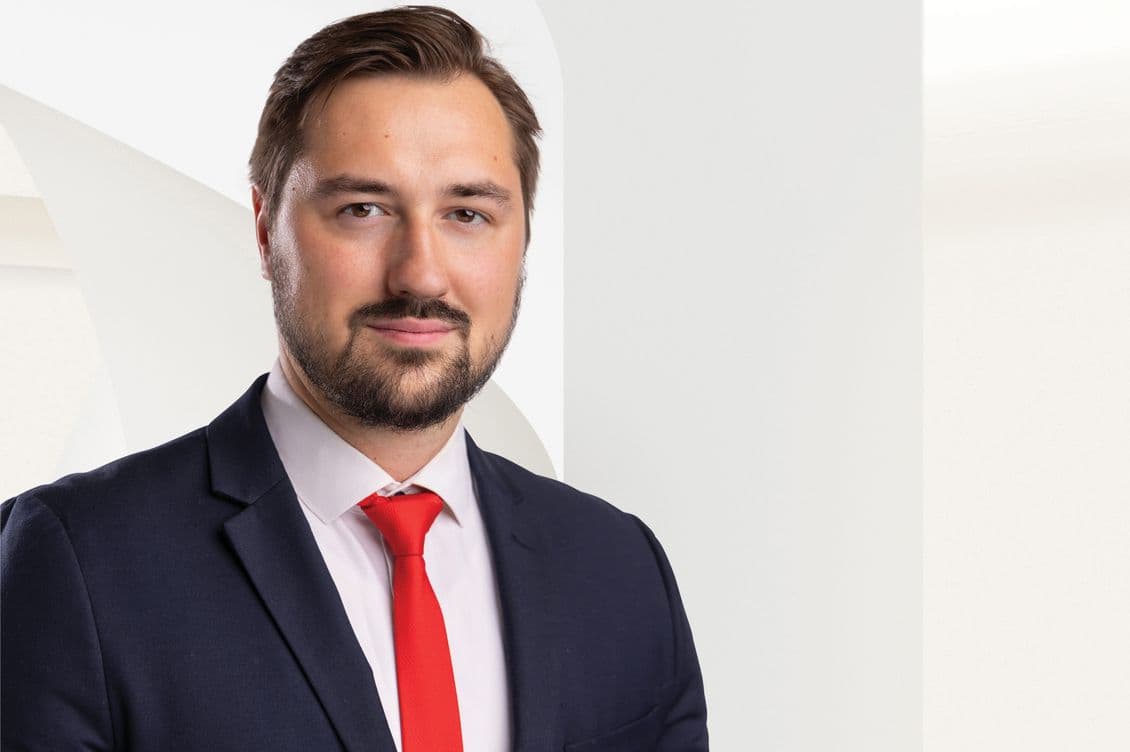 Professional headshot of a male real estate agent with short brown hair and a beard, wearing a dark blue suit with a white shirt and bright red tie. He is looking directly at the camera with a confident expression. The image is being uploaded to the Storyblok content management system, where it's identified as 'Dániel_Gaal_agent_Hungary.jpg' and attributed to Engel & Völkers. This formal portrait is intended for professional use on the company's website or marketing materials.