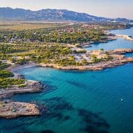You can see the coastline, with some beaches, a few buildings, mountains in the background, and the sea to the right of the photograph.