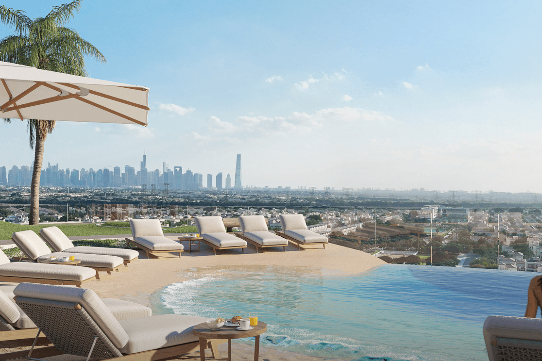 Beach style pool at Voxa featuring a smooth shoreline edge, surrounding palm trees, lounge seating, and views toward the community and nearby high rise buildings.