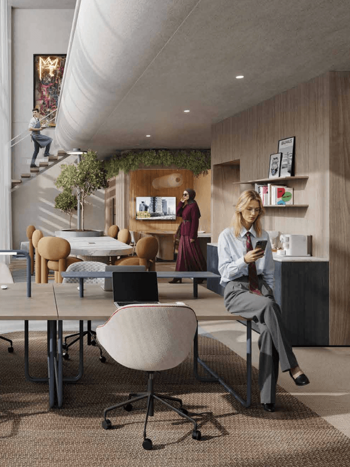 Bright modern office with wood-paneled walls, round tables, plants, and a staircase; coworkers work nearby.