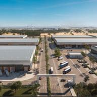 Aerial view of a modern industrial park with large warehouse buildings, trucks, parked cars, and a central entrance gate marked "TERRA LOGYX."