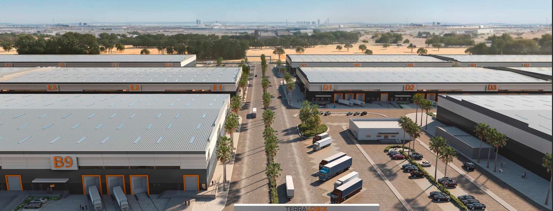 Aerial view of a modern industrial park with large warehouse buildings, trucks, parked cars, and a central entrance gate marked "TERRA LOGYX."