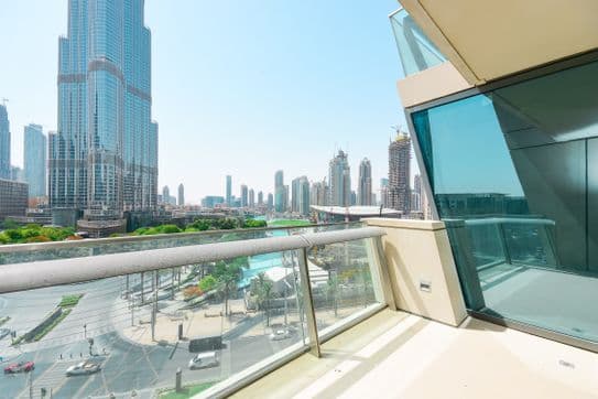 Balcony view from Burj Vista in Dubai overlooking the Burj Khalifa, city roads, and surrounding skyscrapers on a sunny day.