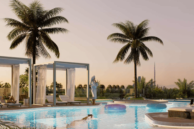 A serene poolside scene at sunset with palm trees, cabanas, a person swimming, and another standing by the pool.