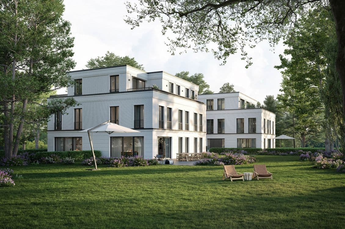 Neubaukomplex für Eigentumswohnungen mit großem Garten, auf der Rasenfläche stehen zwei Liegestühle