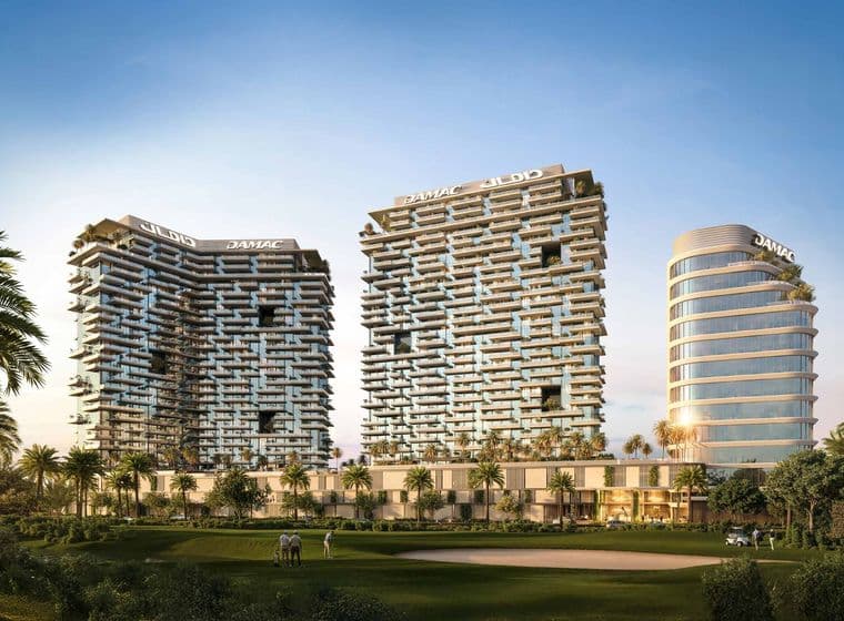 Three modern high-rise buildings with geometric facades, surrounded by palm trees and a golf course under a clear blue sky.