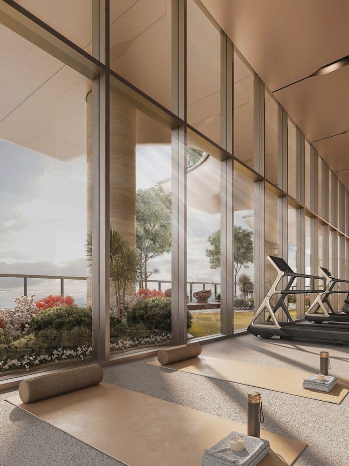 Modern gym with large windows, treadmills, and yoga mats. Indoor plants and warm lighting create a relaxing atmosphere.