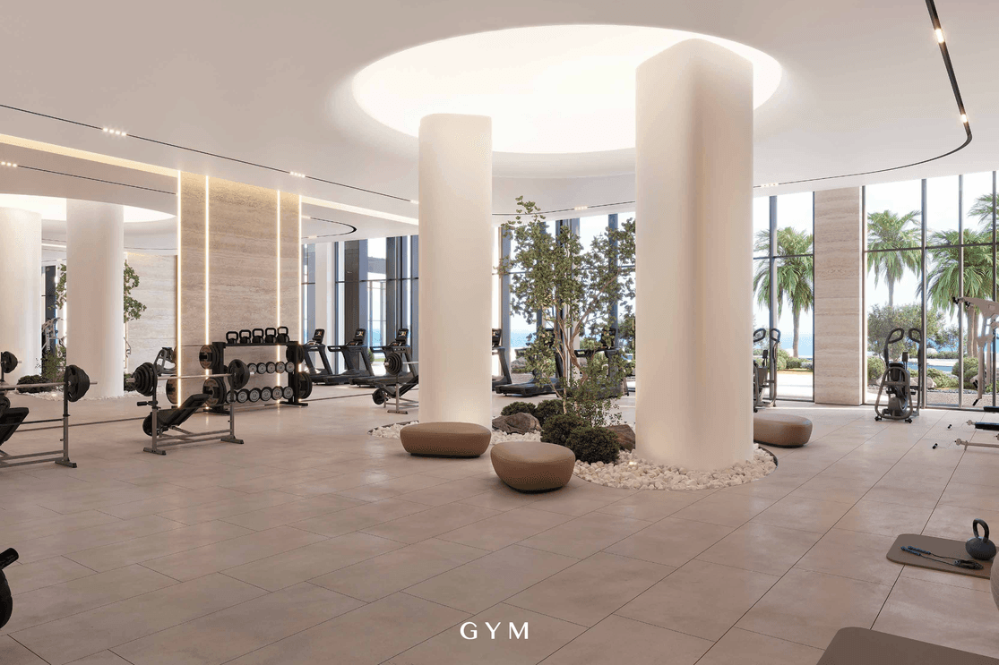 Gym at Playa Viva with modern fitness equipment and large windows overlooking the Al Marjan Island surroundings.
