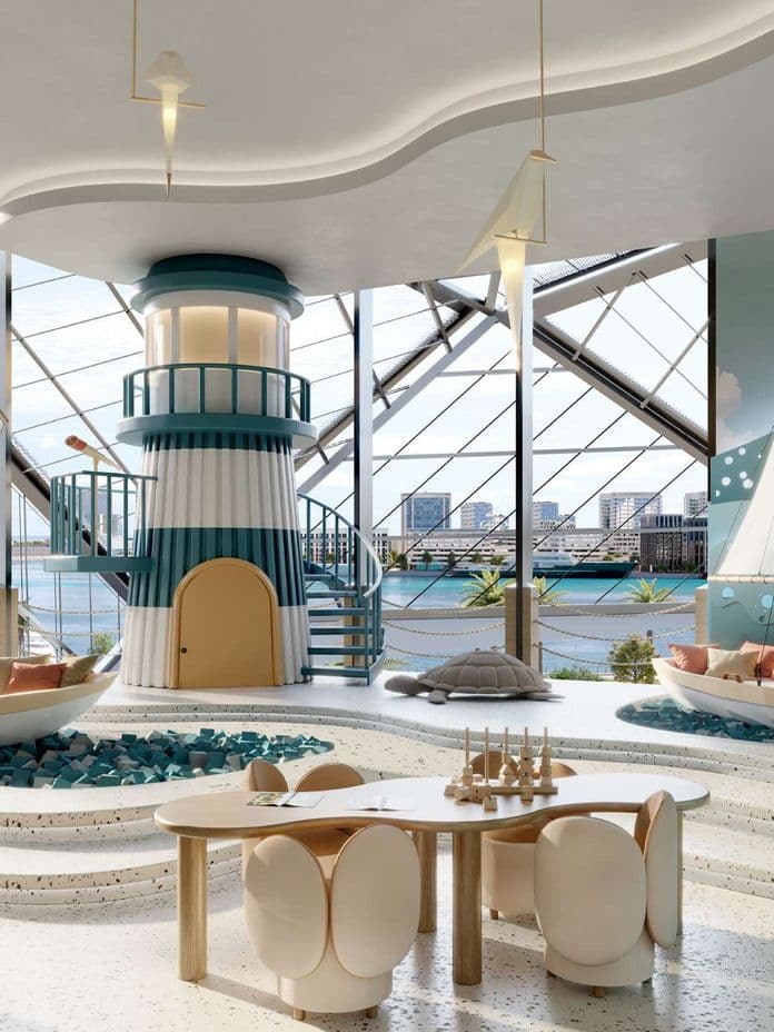 Playful nautical-themed room with sailboats, lighthouse structure, and ocean view. Cozy seating and table with chairs are included.
