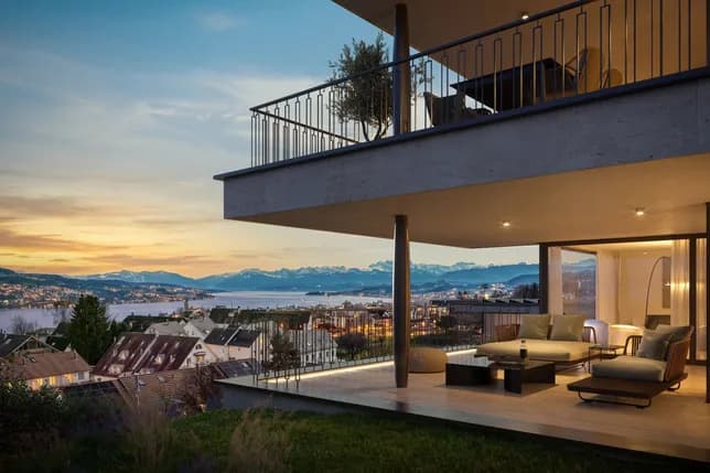 Moderne Terrasse mit Metallgeländer und Sitzgelegenheiten, mit Blick auf den See und die Berge bei Sonnenuntergang.
