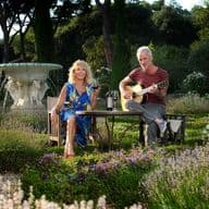 Trudie Styler et Sting assis dans leur jardin en Toscane.