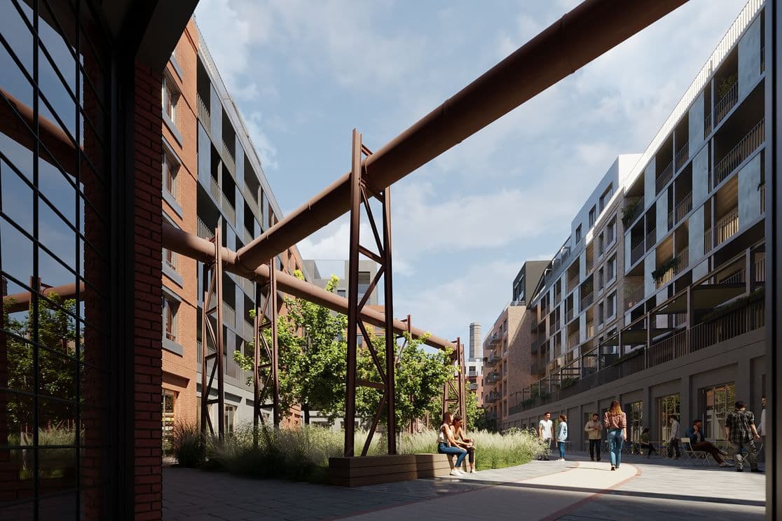 Vnitroblok rezidenčního komplexu s trubkovou konstrukcí připomínající industriální dědictví, kolem jsou moderní bytové domy, lidé sedí na lavičkách a procházejí se.  Alt text (EN):