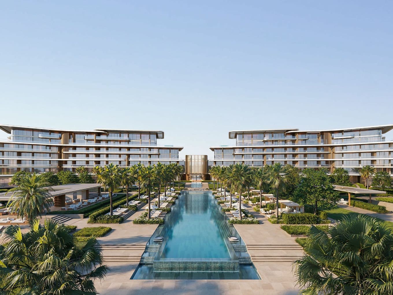 Luxurious resort with modern architecture, surrounded by palm trees and an expansive central pool under a clear blue sky.