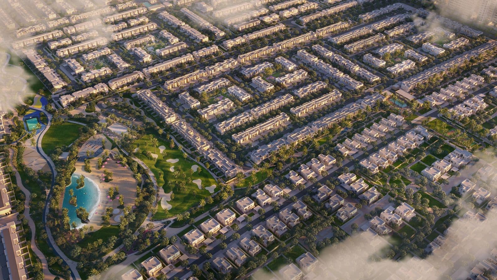 Aerial view of a vast residential complex with uniform houses, green parks, a pond, and curved pathways under a partly cloudy sky.