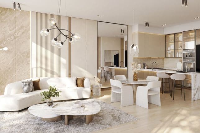 Modern open-plan living room and kitchen with light wood floors, a beige sofa, round marble coffee table, elegant chandelier, and sleek kitchen island.