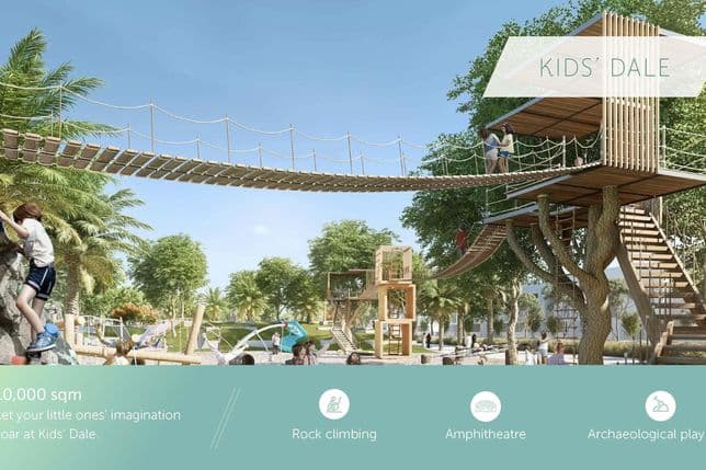Kids' park with a treehouse, rope bridge, climbing wall, and play area in a lush green setting. Amenities include rock climbing and amphitheater.