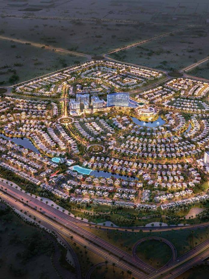 Night aerial view of Hayat Residences master community at Dubai South, with illuminated streets, villas, apartments, and major road connections.