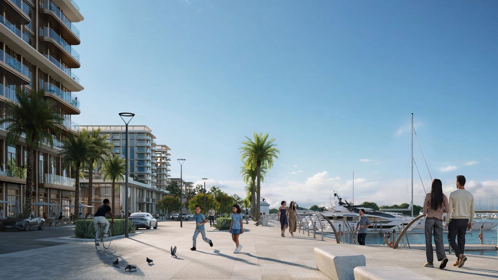 People walking, cycling, and playing along a palm-lined promenade with waterfront cafés and docked yachts, surrounded by modern mid-rise buildings.