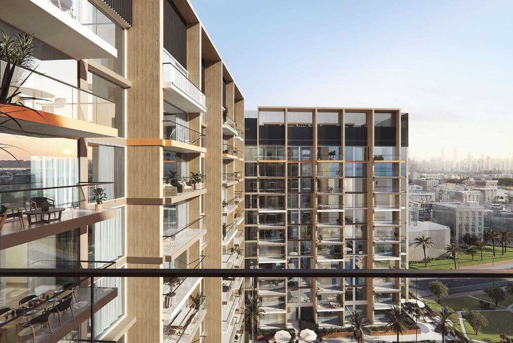 Close-up view of Taiyo Residences balconies, showcasing glass railings, wood-textured exterior panels, and outdoor seating with city views in the background.
