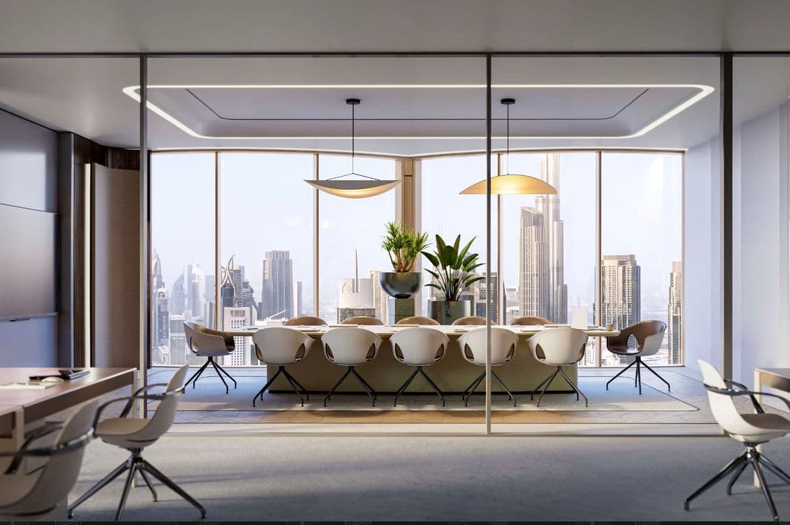 Modern conference room with a long table, chairs, and plants, overlooking a city skyline through large windows.