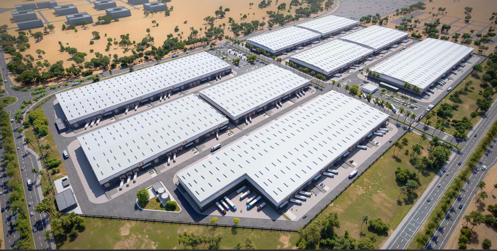 Aerial view of a large industrial complex with multiple white-roofed warehouses surrounded by greenery and roads.