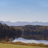 Large Ostersee lake near Iffeldorf, Bavaria, surrounded by forests with views of the Alps