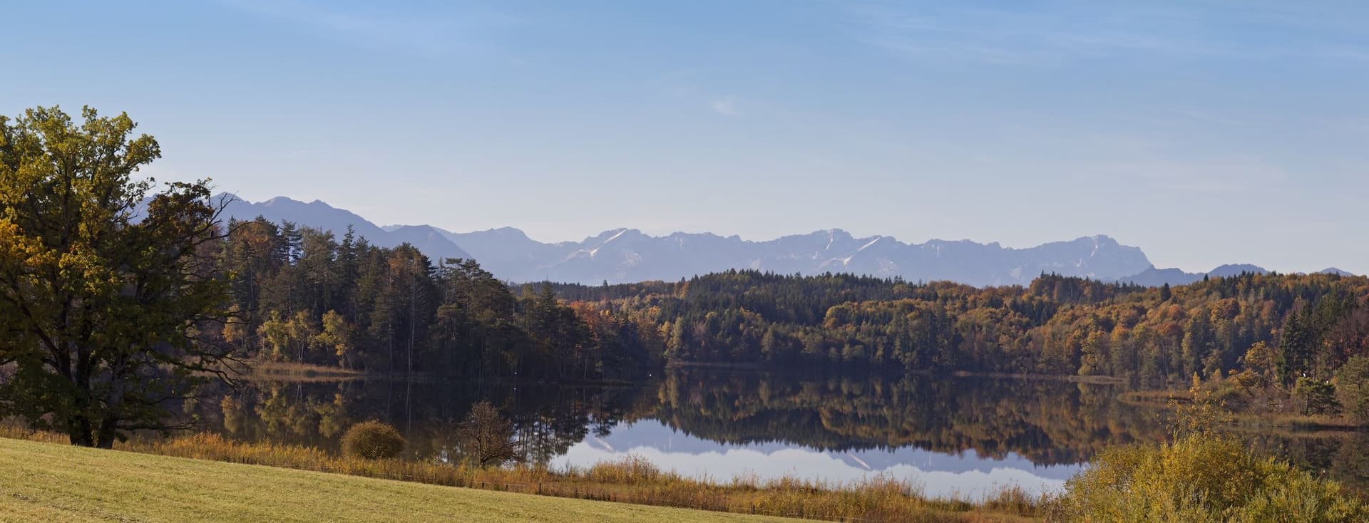 Large Ostersee lake near Iffeldorf, Bavaria, surrounded by forests with views of the Alps
