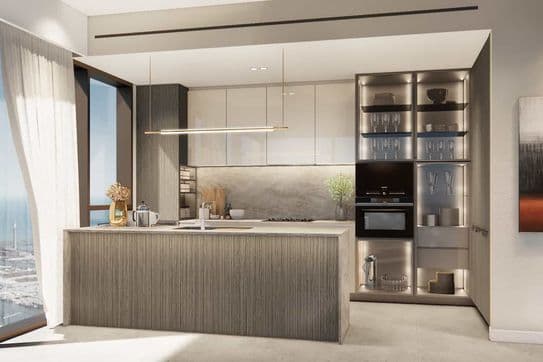 Moderne Küche mit großer Kochinsel, eleganten Schränken, eingebautem Ofen und raumhohen Fenstern mit Blick auf das Meer.