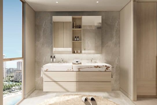 Modernes Badezimmer mit Doppelwaschtisch mit Marmorplatte, großem Spiegel und Holzschränken. Ein Fenster bietet Blick auf die Stadt. Hausschuhe auf einem runden Teppich.