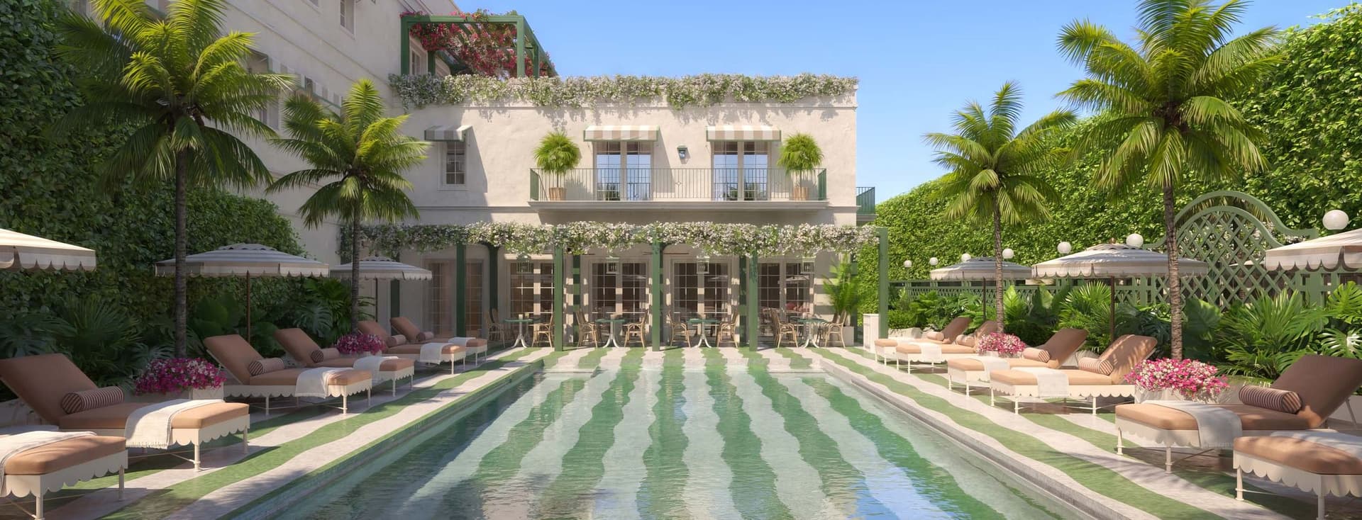 Luxosa zona de piscina exterior amb rajoles a ratlles, envoltada de gandules, para-sols, palmeres i un edifici adornat amb vegetació.