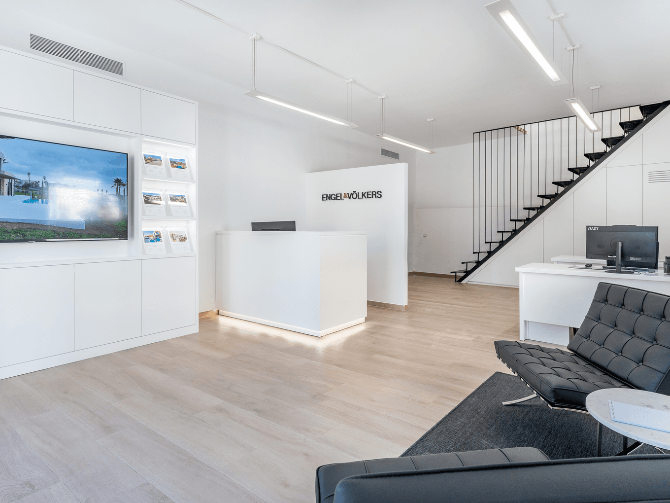 Ein moderner und einladender Empfangsbereich im Immobilienbüro von Engel & Völkers in Santa Maria, Mallorca, mit eleganter Einrichtung und hellem, offenem Design.