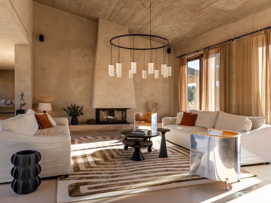 Front view of the Son Gual finca, showcasing its traditional Mediterranean facade, large terraces, natural stone walls, and manicured garden with palm trees.