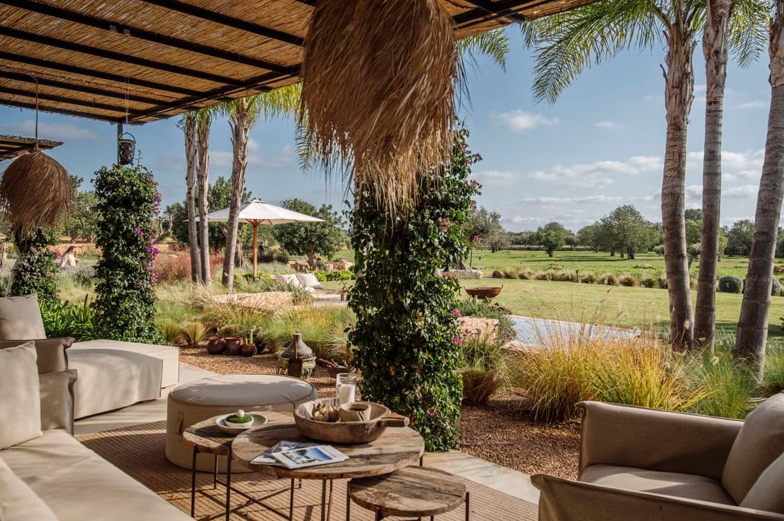 Ampla terrassa amb una gran illa central amb seients de bar, armaris elegants, electrodomèstics integrats i detalls en fusta natural, connectant-se de manera fluida amb les zones de menjador i sala d’estar.