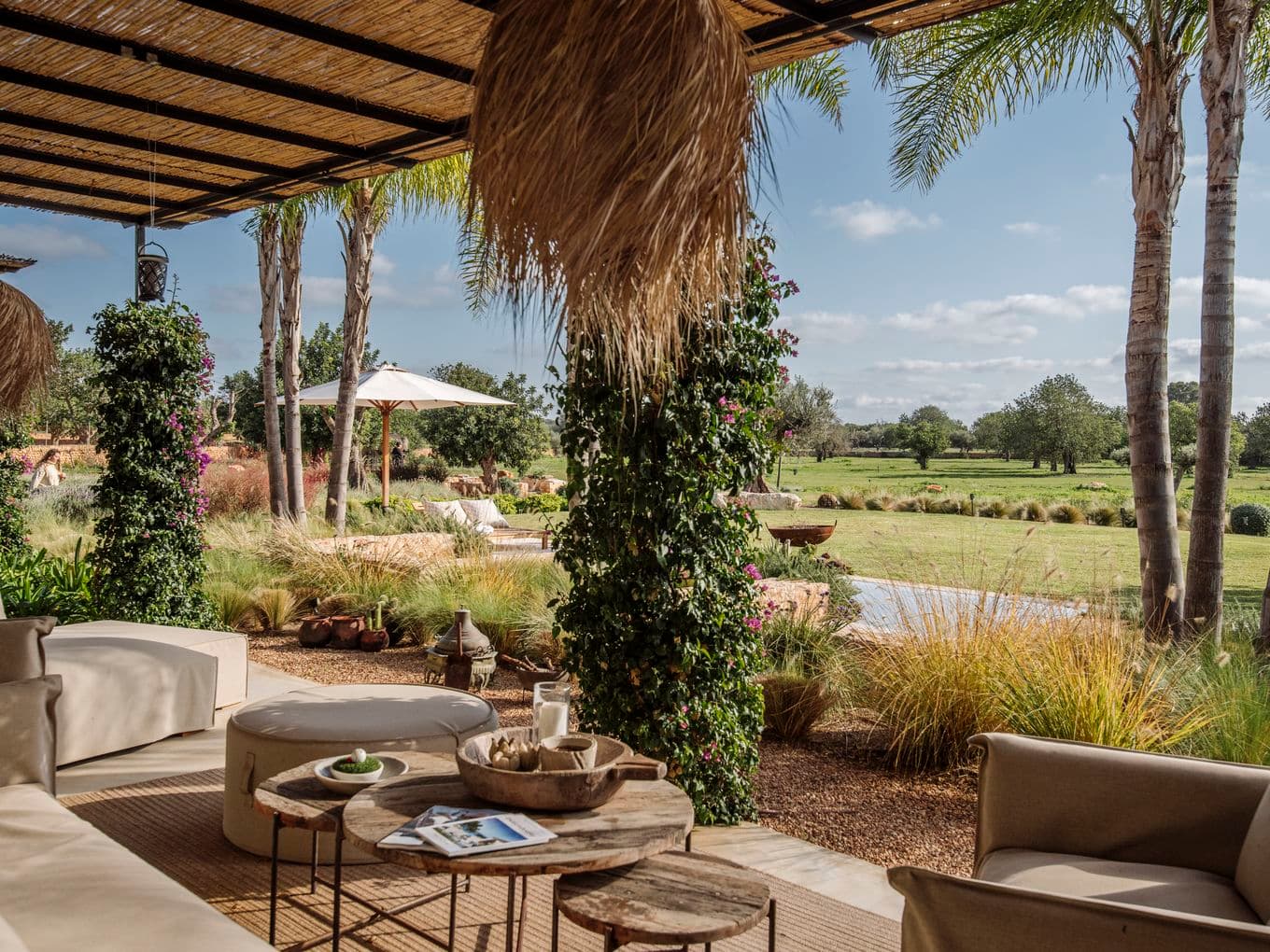 Amplia terraza con una gran isla central con asientos tipo bar, elegantes muebles integrados, electrodomésticos empotrados y detalles en madera natural, que se conecta perfectamente con las áreas de comedor y sala de estar.