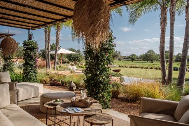 Großzügige Terrasse mit zentraler Kücheninsel und Barbereich, eleganten Einbauten, integrierten Geräten und natürlichen Holzakzenten – nahtlos verbunden mit dem Ess- und Wohnbereich.