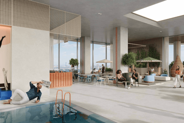 Spacious modern indoor pool lounge with glass walls, greenery, and colorful seating; people relax and chat under umbrellas.